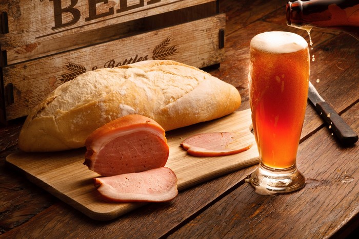 Beer, Bread, and Ham on a Wooden Table