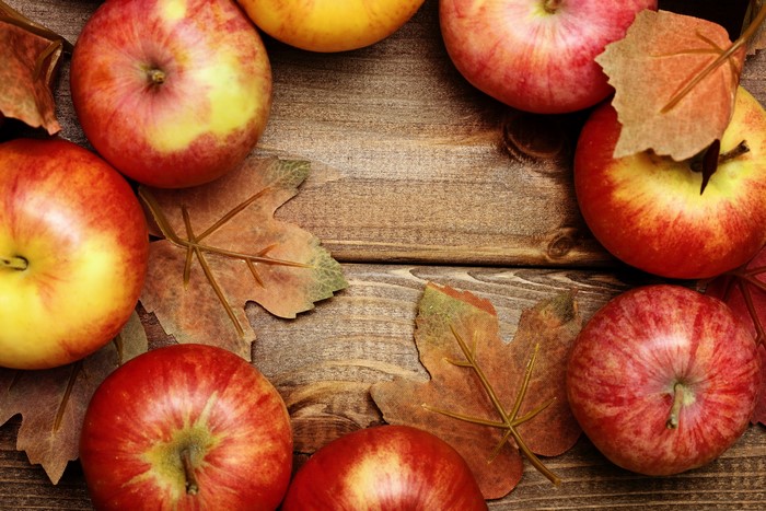 Apples and Autumn Leaves on Wood
