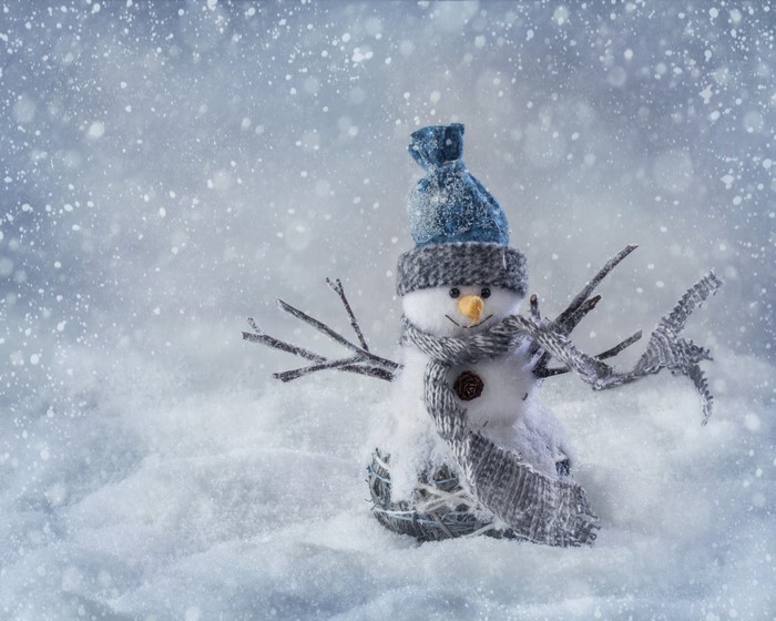 Snowman with blue hat and scarf in snow