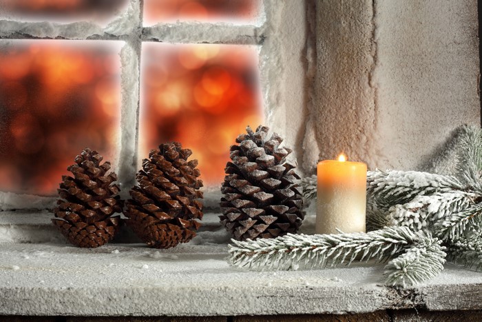 Christmas window with pine cones and candle