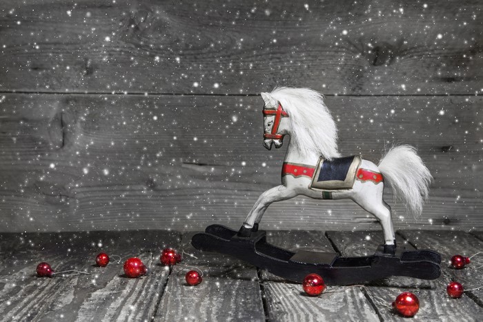 Rocking horse with Christmas ornaments and snow