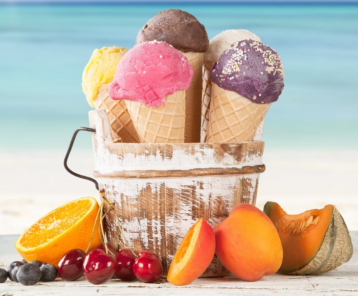 Ice cream cones in a bucket with fruit on a beach