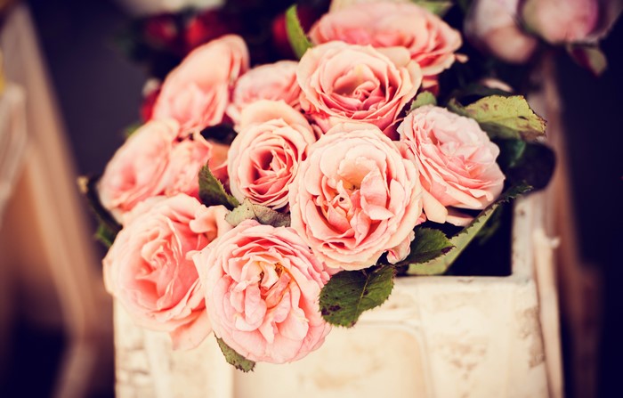 A bouquet of pink roses in a rustic crate