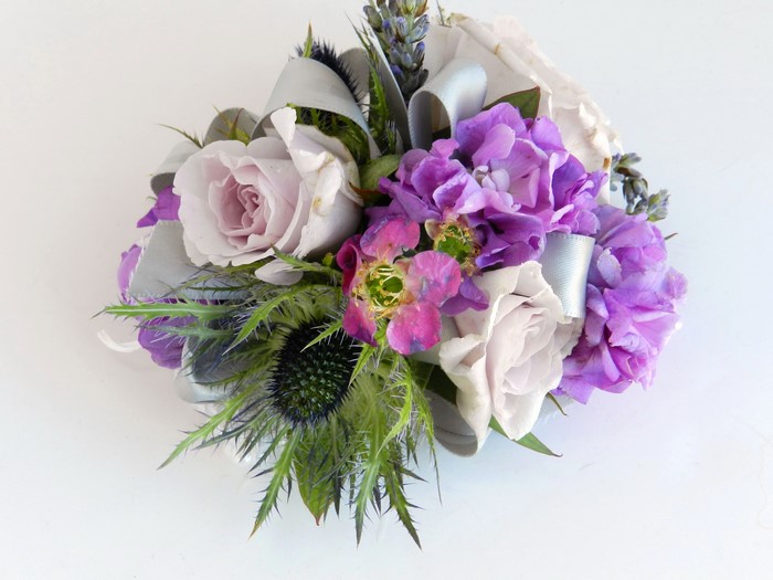 Purple and white floral arrangement with thistle and ribbon