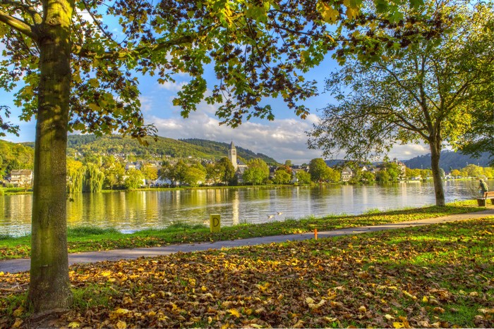 Riverfront town with church tower and autumn foliage