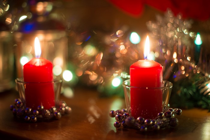 Two red candles with Christmas lights