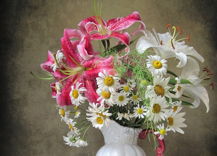 Pink and white lilies with daisies in a vase