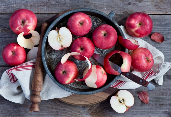 Apples and a knife on a wooden table