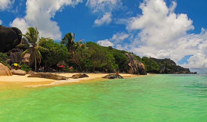 Tropical beach with palm trees and granite boulders