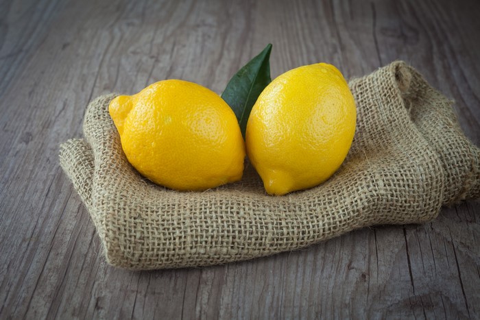 Two lemons on burlap with a leaf