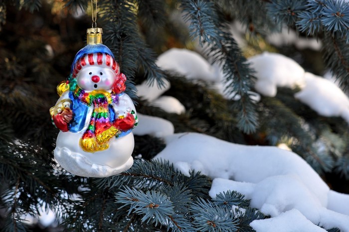 Snowman ornament on a snowy Christmas tree