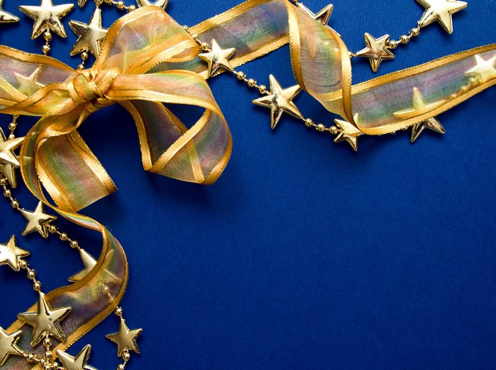 Gold ribbon and star garland on blue background