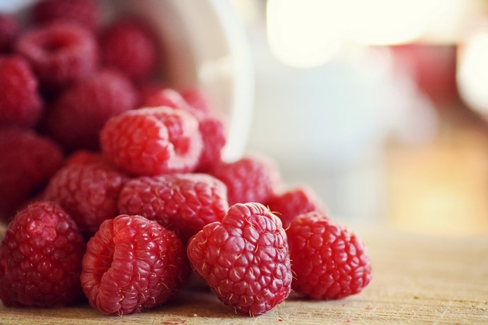 Close-up of fresh raspberries spilling from a container