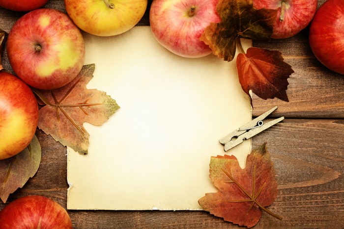 Apples and autumn leaves on a wooden table