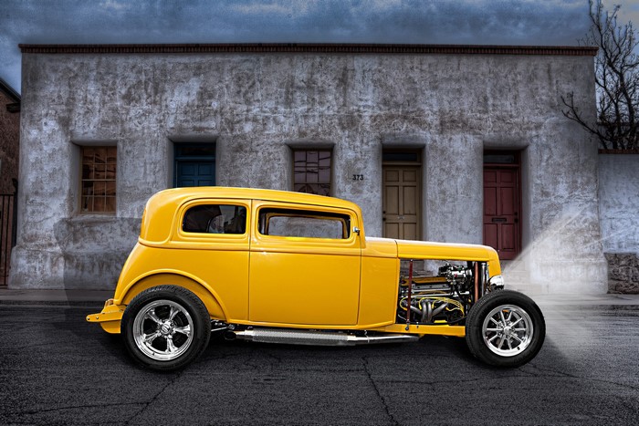 Yellow Rat Rod parked in front of a stucco building