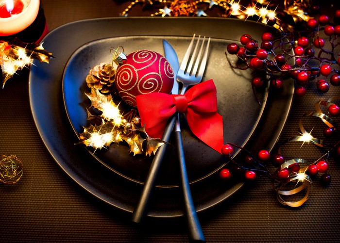 Christmas table setting with red ornament and berries