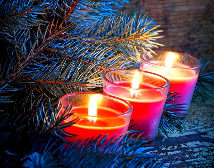Three lit candles and pine branches