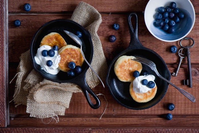 Pancakes with blueberries and cream in cast iron pans