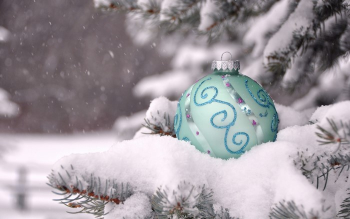 Christmas ornament on a snow-covered pine branch