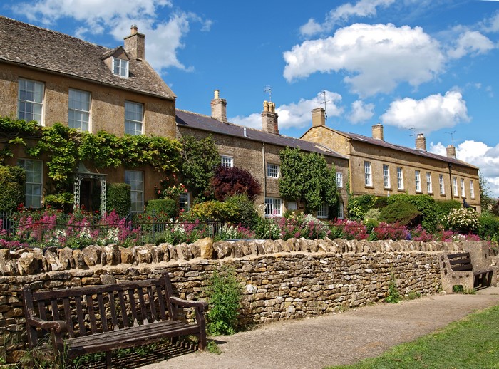 Stone houses with flowers and a bench in Blockley, UK