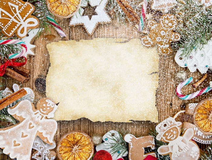 Christmas cookies and parchment on wooden table