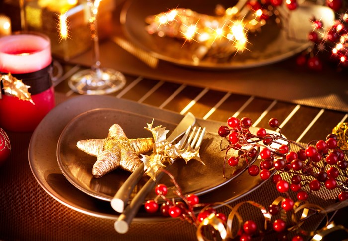 Christmas table setting with red candle and berries