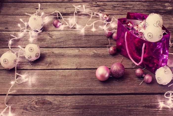 Christmas ornaments and fairy lights on wooden background