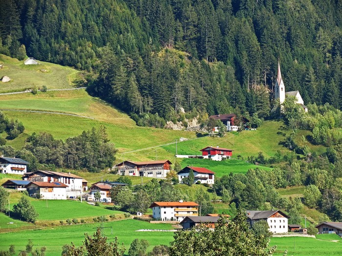 Village with church in a green mountain valley