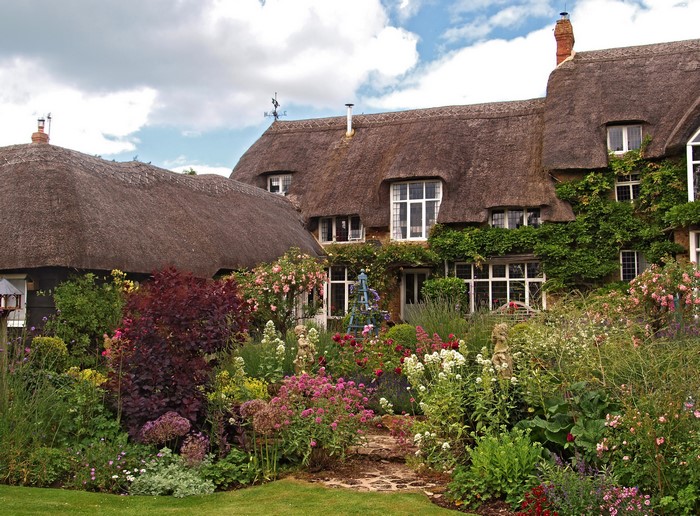 Thatched cottage with a vibrant flower garden in Oxfordshire, England