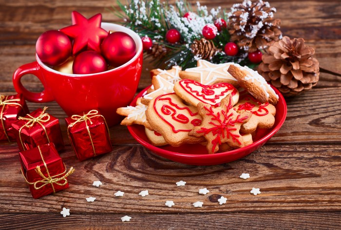 Christmas cookies, ornaments, gifts, and pine cones on wood