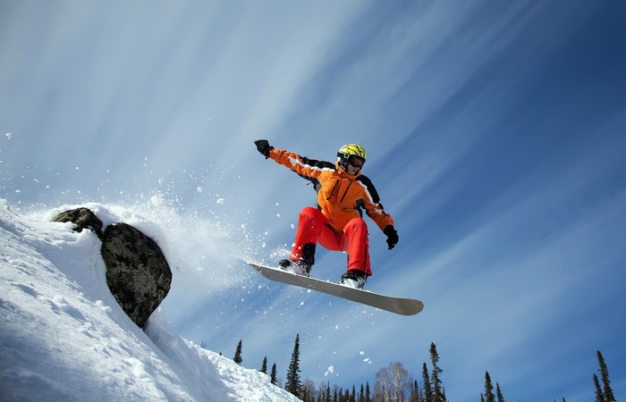 Snowboarder jumping off a snowy ledge