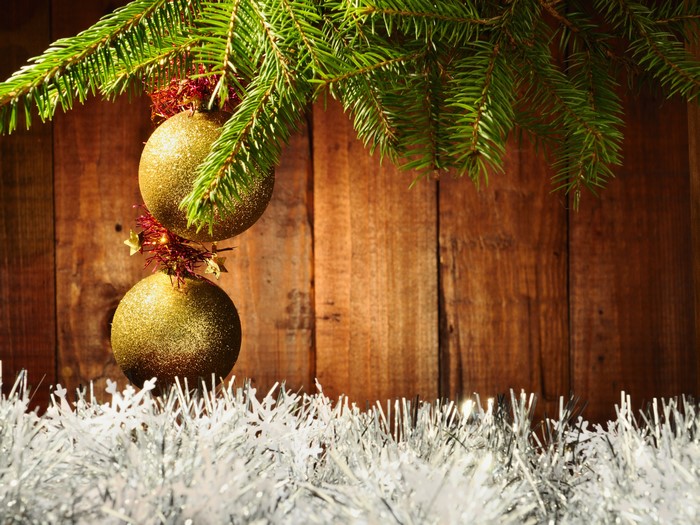 Christmas tree branches with golden ornaments and tinsel