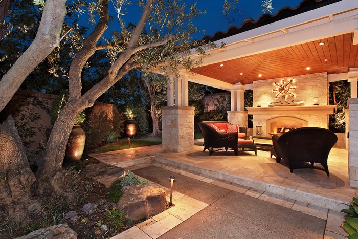 Outdoor patio with fireplace and seating at night