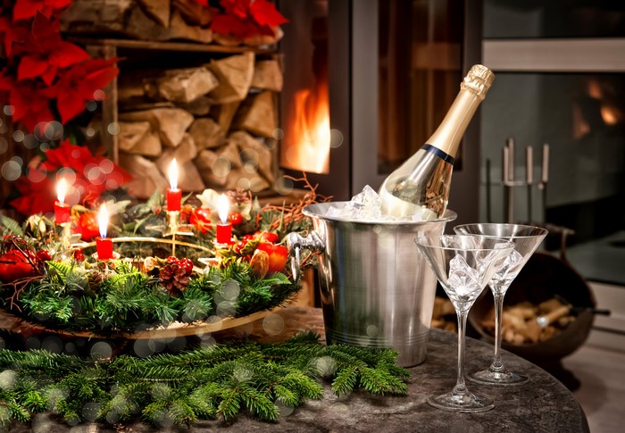 Christmas Wreath with Candles, Champagne, and Glasses by Fireplace