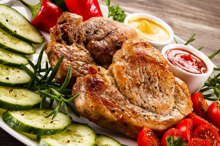Meat products with cucumbers, tomatoes, ketchup, and mustard