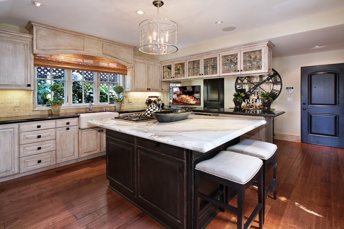 Kitchen with island, chandelier, and door