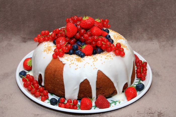 Bundt cake with white icing and berries