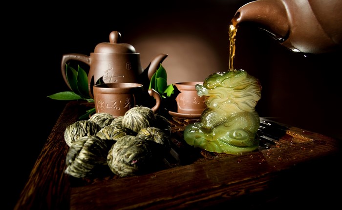 Tea ceremony with teapot, cups, and blooming tea