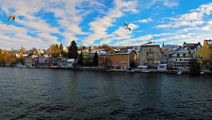 Gmunden, Austria: Lakeside houses and seagulls under a cloudy sky