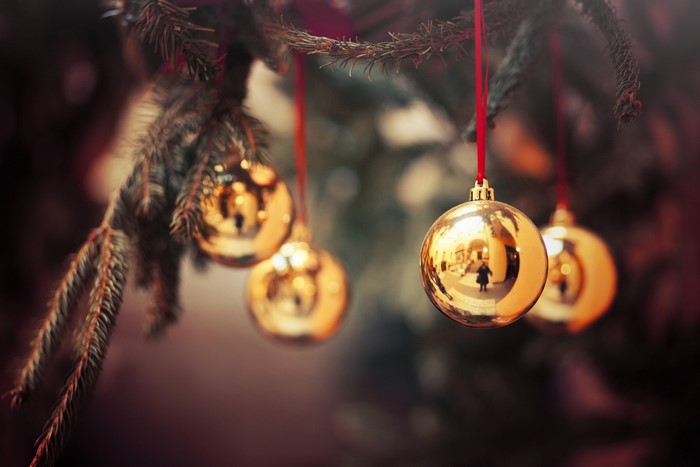Golden Christmas ornaments hanging on a tree branch
