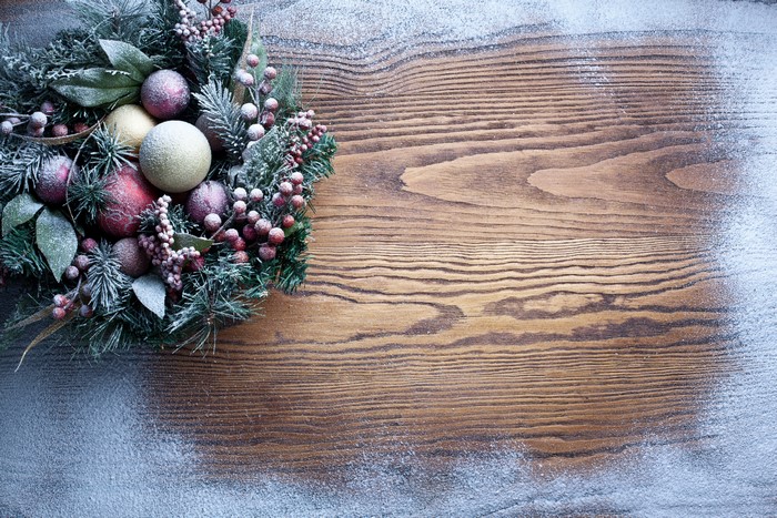 Christmas wreath with ornaments on wooden table