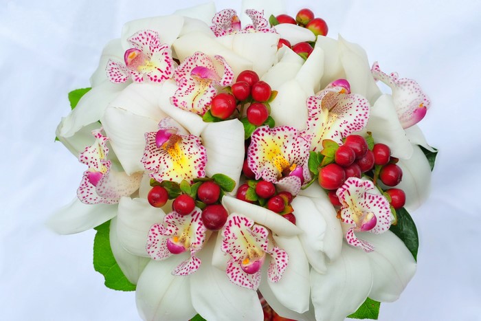 White orchids and red berries bouquet