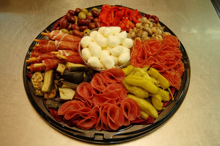 Charcuterie board with meats, cheeses, and vegetables