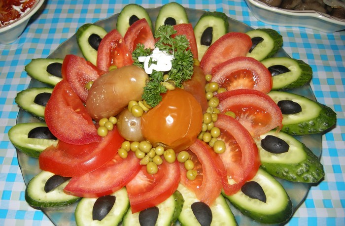 Vegetable platter with tomatoes, cucumbers, olives, and peas