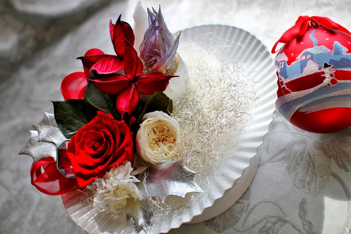 Christmas floral arrangement with red roses and ornament