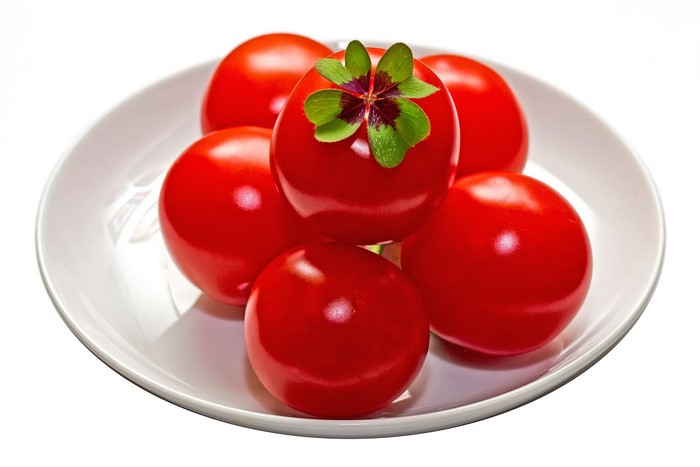 Tomatoes with a four-leaf clover on a plate