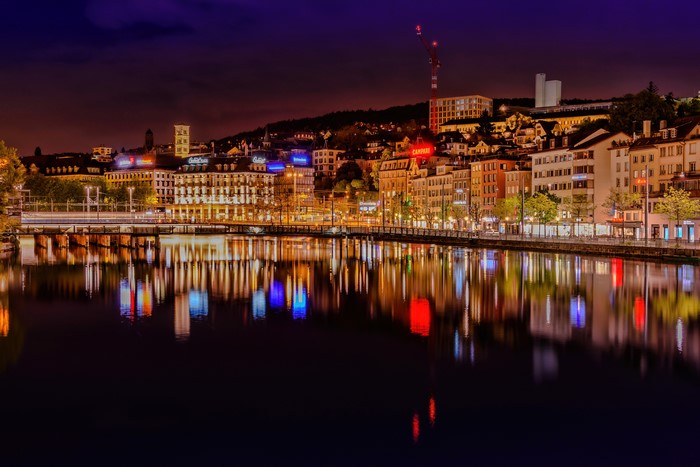 Zurich cityscape at night with river reflections
