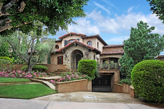 Mediterranean style mansion with landscaping and driveway