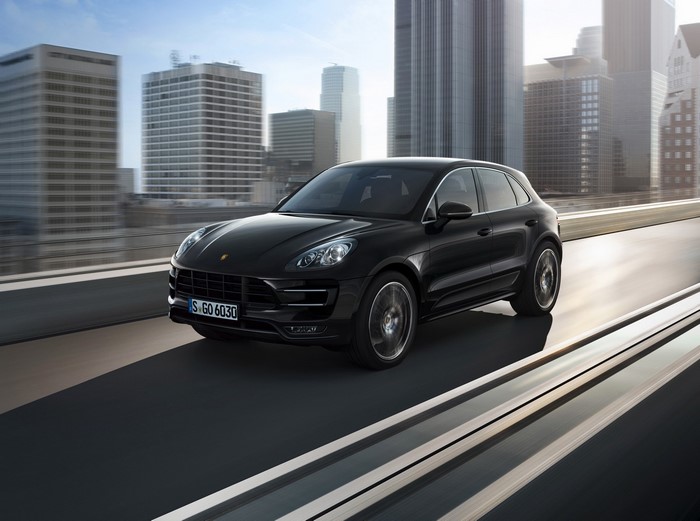 Black Porsche Macan Turbo driving on a city highway