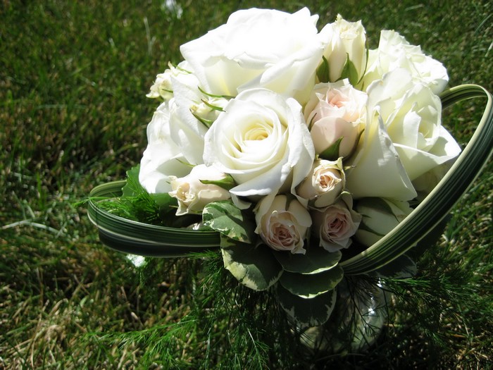 White roses bouquet on green grass